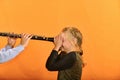 The boy plays the clarinet in the girlÃ¢â¬â¢s ear, the outraged girl waves her arms